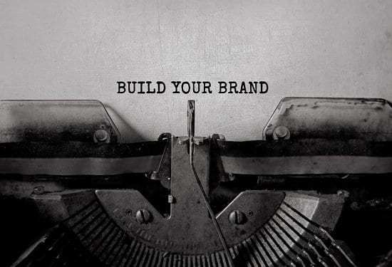 "Build your brand" typed words on a vintage typewriter for a brand marketing concept.